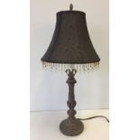 A table lamp with brown shade with drops.