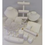A box of white leather effect jewellery display stands.