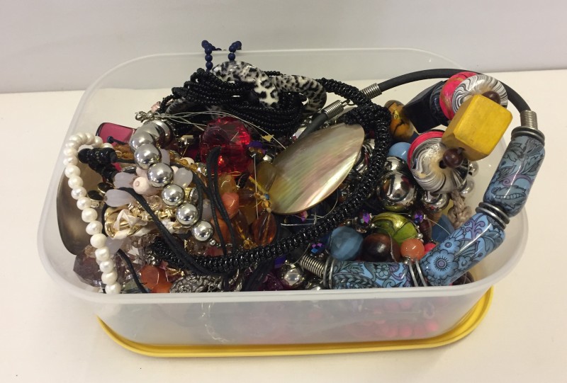 A container of costume jewellery to include necklaces & bracelets.