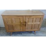 A light wood Ercol sideboard.