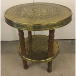 An oriental brass and wood circular table.