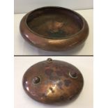 An Arts & Crafts copper bowl with rope decoration to rim and around ball feet.