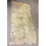 A long haired, cream colour, animal hide rug.