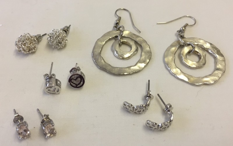 5 pairs of white metal earrings.