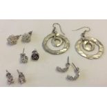 5 pairs of white metal earrings.