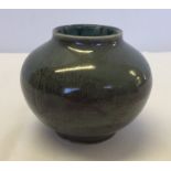 A small studio pottery squat shaped vase of green colouration.