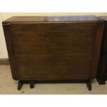 A dark oak drop-leaf gate leg dining table.