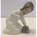 A Lladro figurine of a young girl with slippers. Model #4523
