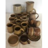 A box of assorted studio pottery jugs and mugs.