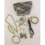 A Christina Aguilera black lace evening bag containing costume jewellery.