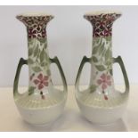 A pair of twin handled French Luneville vases with floral design.