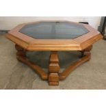 An octagonal oak and glass coffee table.