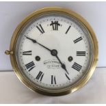 A vintage brass bulkhead clock with enamel dial.