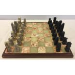 A complete chess set. Board made from marble with sandstone chess pieces.