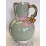 A large Victorian jug with scallop shell design and dolphin handle.