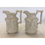 A pair of white ceramic early Victorian wine jugs with classical design.