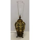A vintage amber glass lamp base with black metal work overlay.