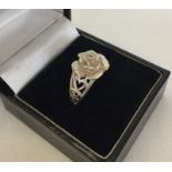 Hallmarked silver ring with central rose design and pierced heart shoulders.