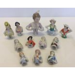 A quantity of 12 ceramic half dolls of various sizes.