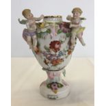 A continental vase decorated with 2 putti & flowers.