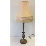 A brass effect table lamp with pineapple decoration and peach coloured shade.