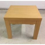 A modern beech effect square coffee table.
