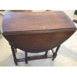 An oak dropleaf table with barley twist legs.