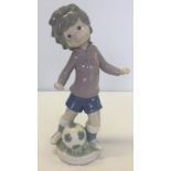 A boxed Lladro figurine of Sport Billy playing football (boy).