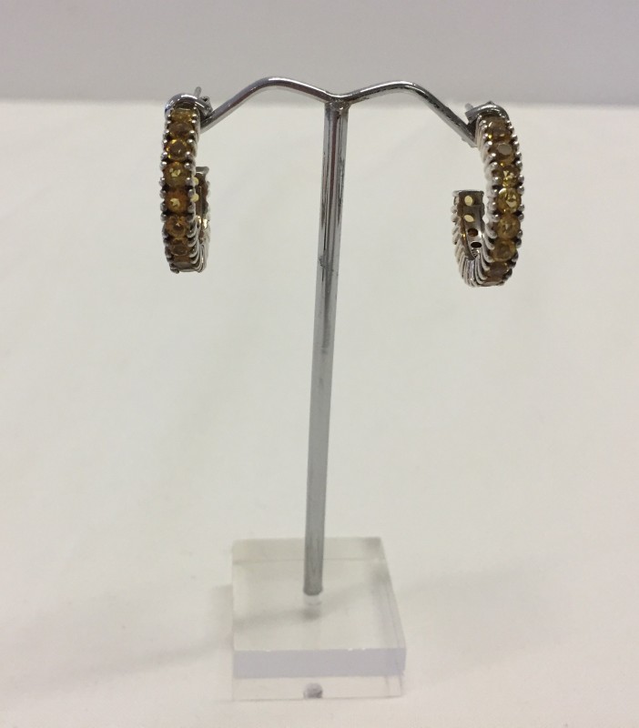 A pair of silver hooped earrings set with citrines.