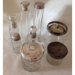 A collection of antique & vintage glass jars/bottles with silver lids.