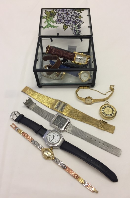 A glass box containing a quantity of ladies & gents watches.