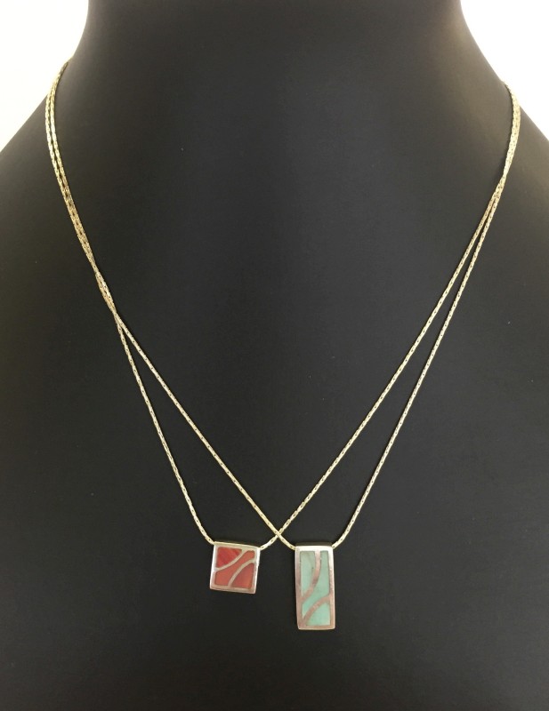 2 modern silver pendants on chains.