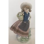 A retired Lladro porcelain figurine of a girl holding a basket.