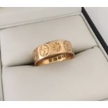 An 18ct hallmarked wedding band with decorative engraving.