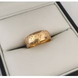 A small 18ct gold wedding band with abstract engraving.