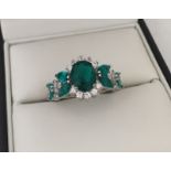 Ornate dress ring set with green & clear stones.