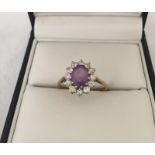 A 9ct gold dress ring set with central oval amethyst surrounded Cubic Zirconia's.