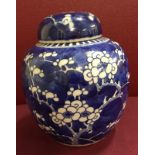 A blue and white oriental lidded ginger jar with cherry blossom design.