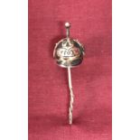 A white metal stick pin of a WW1 German Pickelhaube helmet.