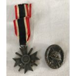 A WW2 German War Merit Cross with swords and wound badge.