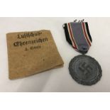 A WWII German Luftshuz medal and packet (torn).