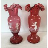 A pair of cranberry glass Mary Gregory style vases.