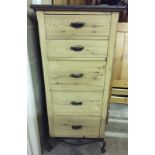 A 5 drawer pine chest with wrought iron legs, handles and banding.