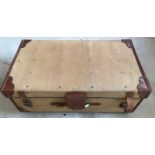 A vintage travelling trunk with leather banding and straps.