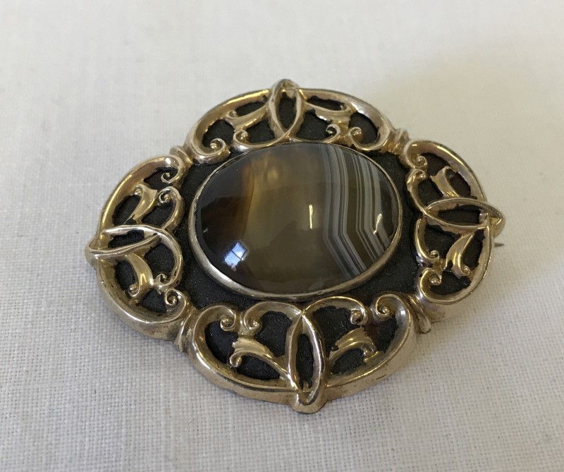 A vintage decorative mourning brooch set with central polished natural agate.