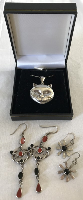 A 925 silver cat shaped locket on a silver chain.