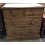 A 2 over 2 solid pine chest of drawers.