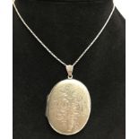 A large oval hallmarked silver locket on a white metal chain.