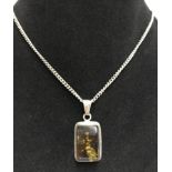 A green amber oblong shaped pendant on a 925 silver chain.
