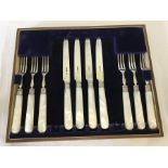 A boxed set of silver bladed fruit forks and knives with mother of pearl handles and silver mounts.